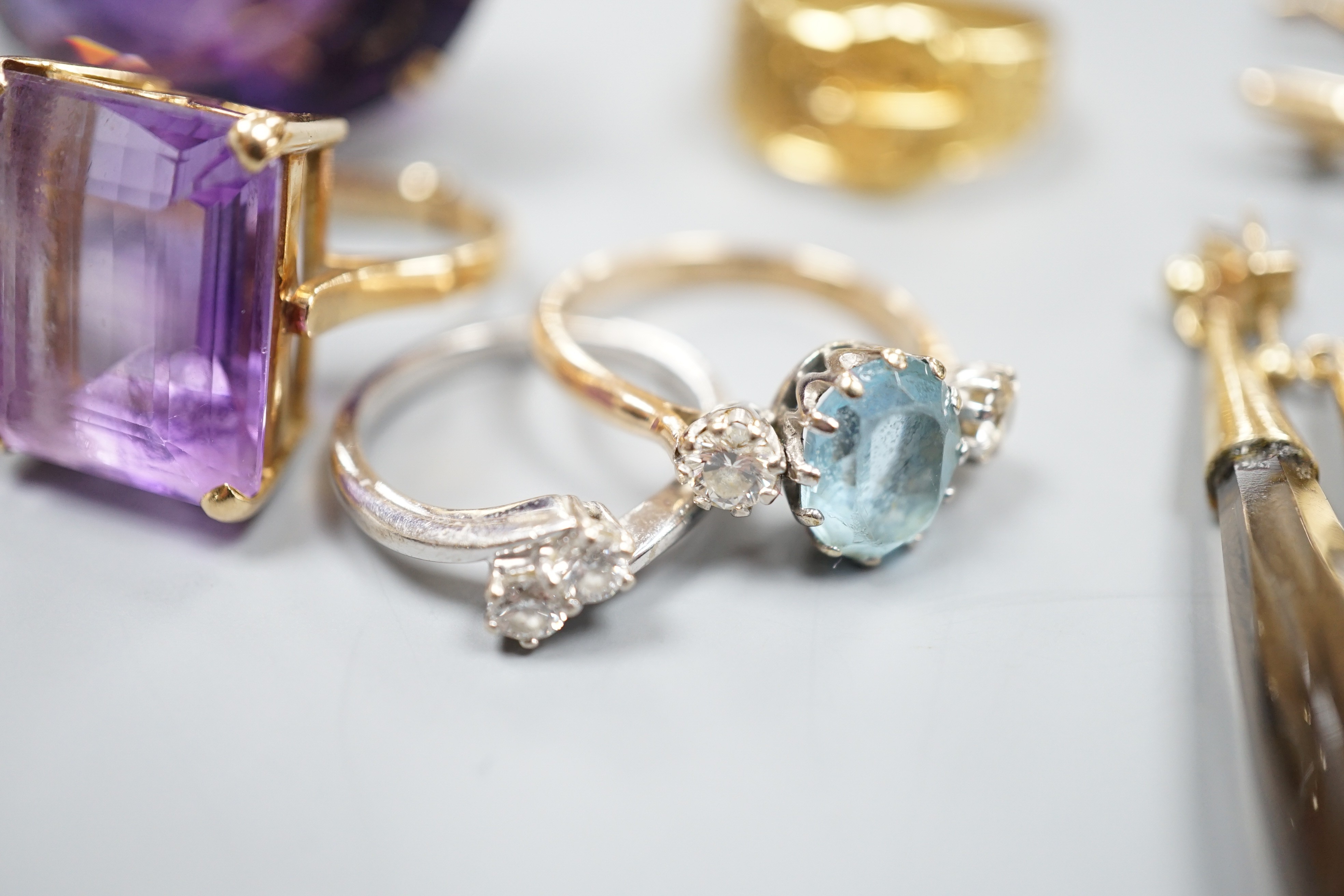 A large 9ct and oval cut amethyst dress ring, size L, three other rings including a 9ct gold buckle ring, an 18ct white gold and two stone crossover ring, two gem set bar brooches including 15ct and three assorted pairs